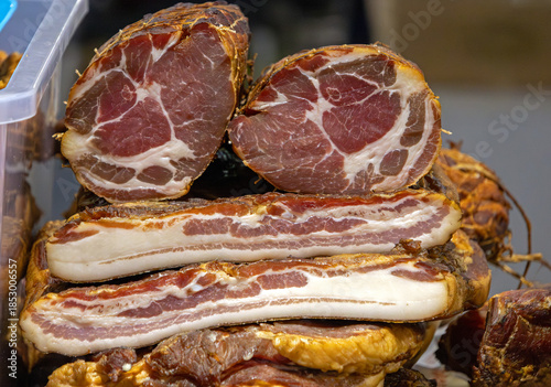Homemade dry cured smoked bacon and ham meat sold on market