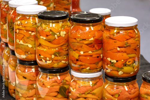 Red pickled peppers inside mason jars in home pantry