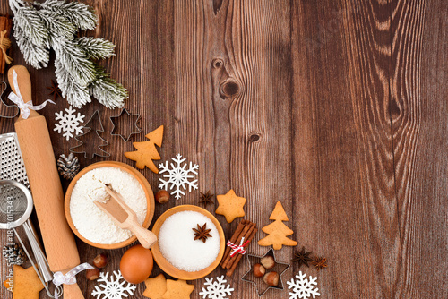 Festive Christmas background. Gingerbread baking preparation on a rustic wooden table during the holiday season
