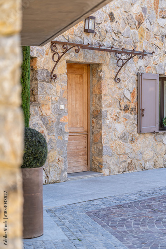 Fotografi Stone villa entrance with wooden door and Mediterranean architecture