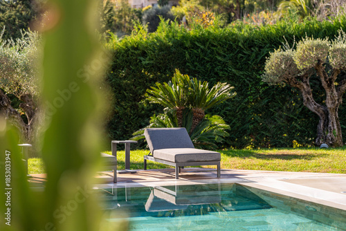 Luxury villa poolside with sun loungers and lush landscaped garden