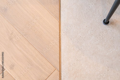 Minimalist interior floor detail with wooden parquet and concrete surface transition in modern design