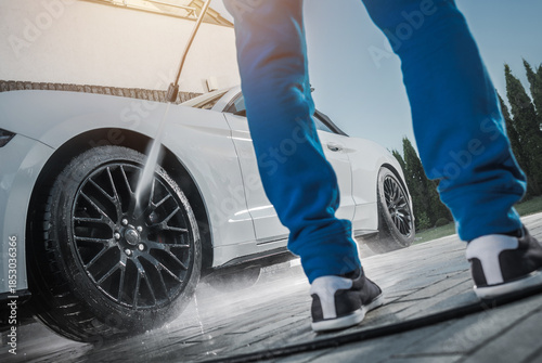 Φωτογραφία Person Washes Car Wheels at a Driveway on a Sunny Day
