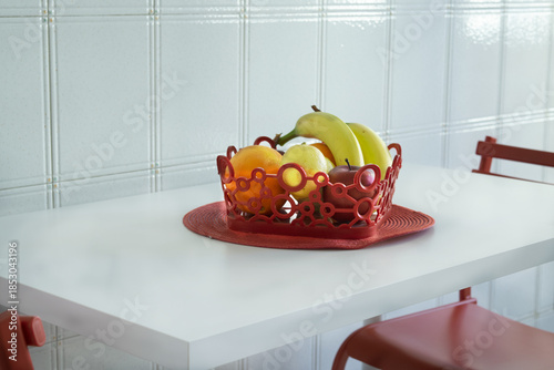 fresh fruit in red decorative basket on a white kitchen counter