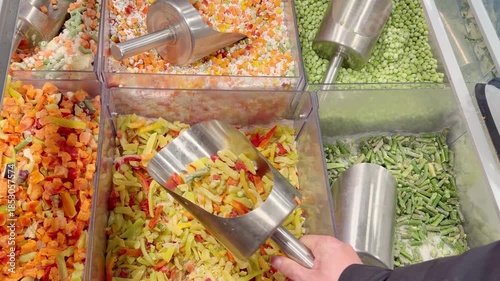 choosing frozen food from a supermarket freezer, reading product information