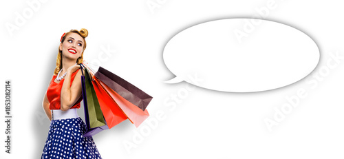 Black Friday Sales concept - beautiful cute blond woman in pinup pin-up dress holding carrying colourful shopping bags isolate white background with empty mockup speech bubble. Mock up design ad image