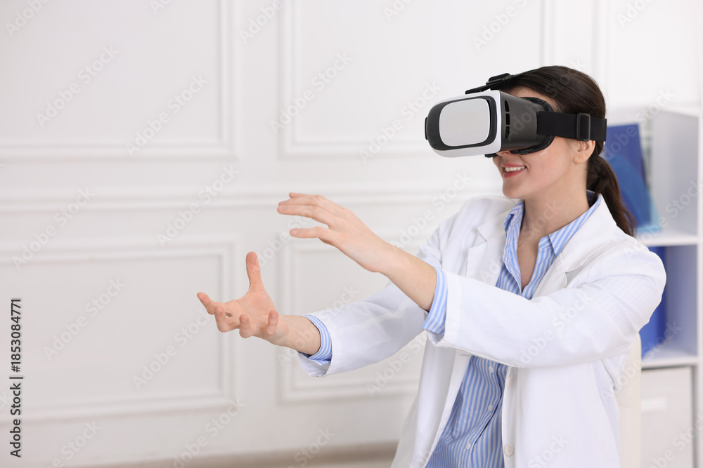 Naklejka premium Modern technology. Doctor using virtual reality headset in clinic, space for text