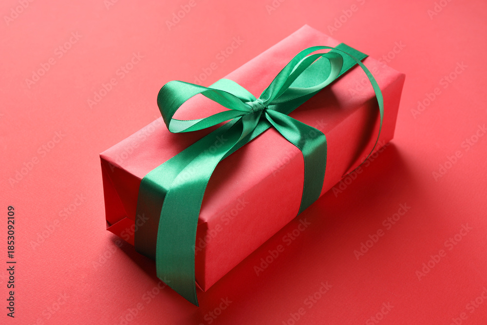 Obraz premium Beautiful gift box on red background, closeup