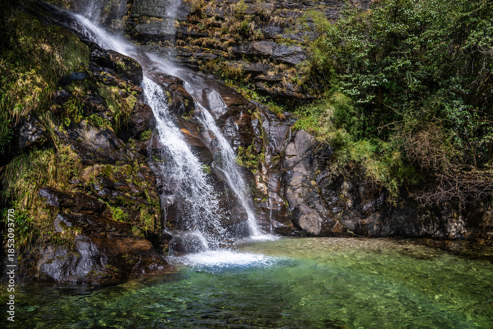 Naklejka premium A waterfall and a small water pond full of clean water on the way to Namche bazaar town. Everest base camp trek, Nepal.