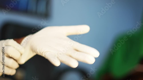 Close-up video of a man wearing protective gloves, representing hygiene, safety, and medical or cleaning preparation in a professional environment.