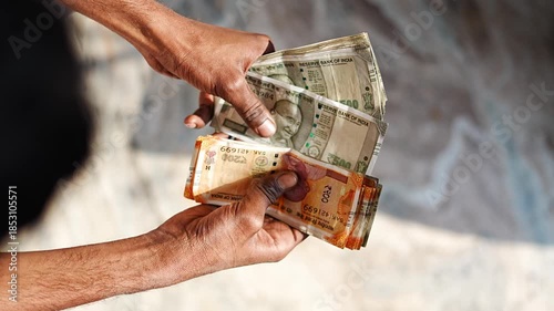 Man counting Indian rupee notes placed on table, representing financial calculation, income, and cash flow.
