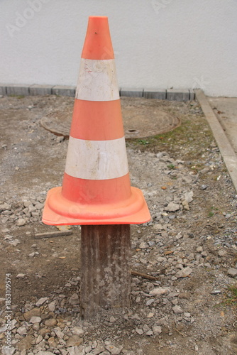 Holzbrett ist mit einem Leitkegel gegen überfahren gesichert