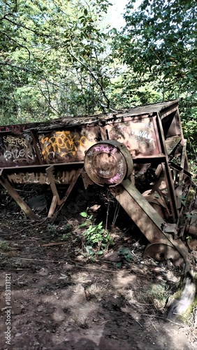 Machine agricole abandonnée envahie par la végétation