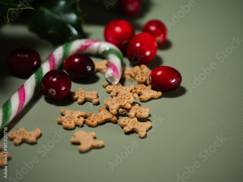Christmas gingerbread men minature cookies wiith candy cane green background