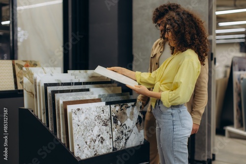 Photography Couple choosing ceramic floor tiles in showroom