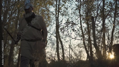 Spanish conquistador walks alongside a priest through the American jungle at sunset
