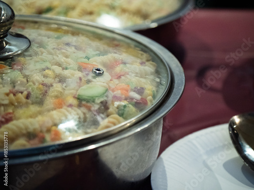 Big pan of pasta and vegetables at buffet