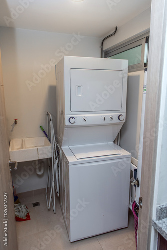 Stacked washer and dryer unit in compact laundry space
