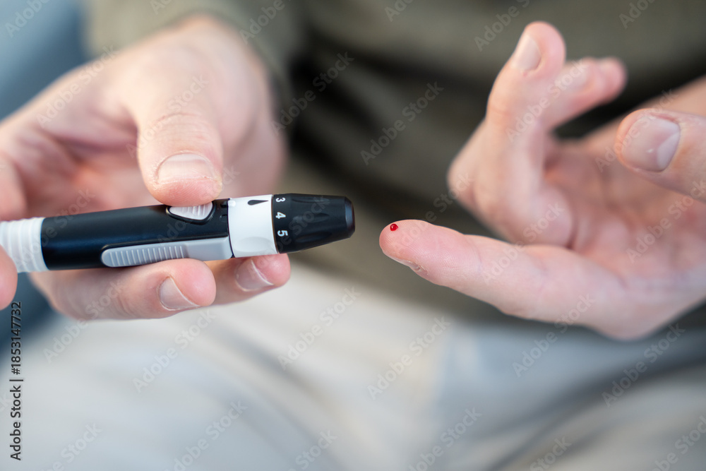 Fototapeta premium Person checking blood glucose level with lancet