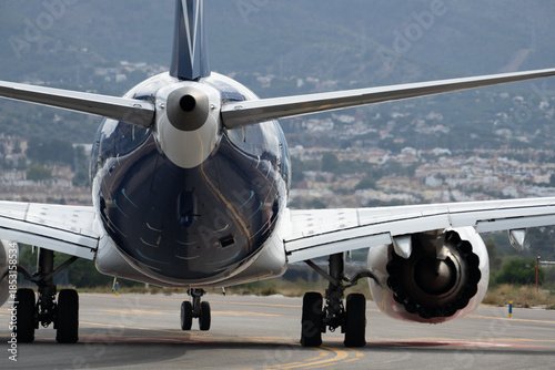 фотографія Commercial airplane on runway with mountainous backdrop