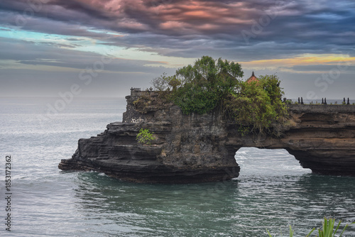 The natural rock arch at the Pura Batu Bolong near Tanah Lot Temple in Bali, Indonesia