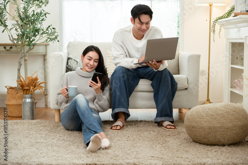 Couple Relaxing at Home in Winter While Using a Laptop and Enjoying Drinks Together