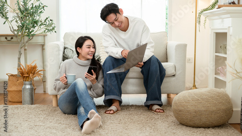 Couple Relaxing at Home in Winter While Using a Laptop and Enjoying Drinks Together