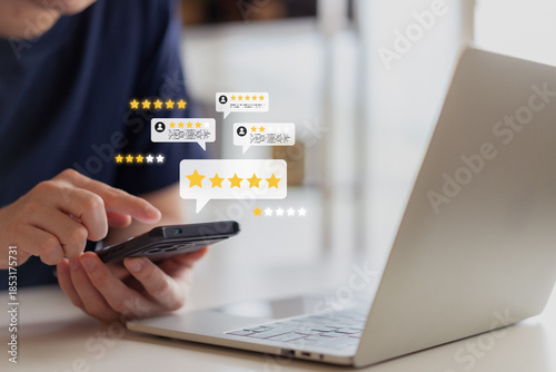 Close up of man using smartphone and laptop with five star rating icons. Concept for customer review, online reputation management, best quality service, and user feedback satisfaction.