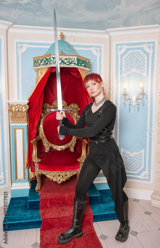 Beautiful redhaired woman warrior with sword standing near the throne