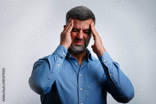 Canvas Print Portrait of man isolated on gray background, suffering from severe headache, pre