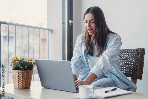 Funny euphoric young caucasian woman celebrating winning or getting ecommerce shopping offer on computer laptop. Excited happy girl winner looking at notebook celebrating success