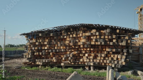 Pile of wooden square logs stacked on the construction site. Dolly camera