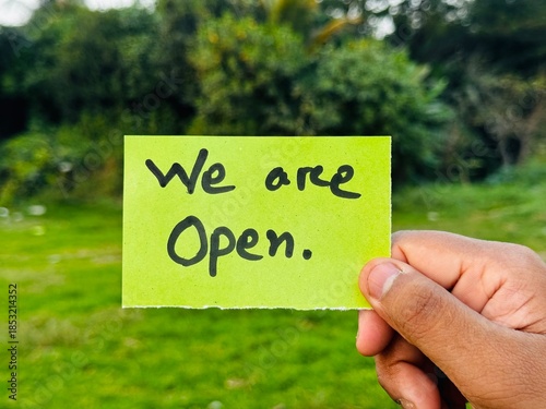 We are open hand note, We're open now sticky note hanging