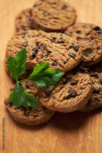 Freshly Baked Chocolate Chip Cookies on a Wooden Board With Green Garnish