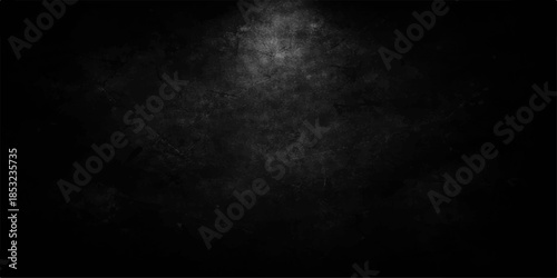 A dark and vintage black and white grunge background featuring a textured concrete wall surface with subtle smoke patterns and a blank grey paper backdrop for old design wallpaper