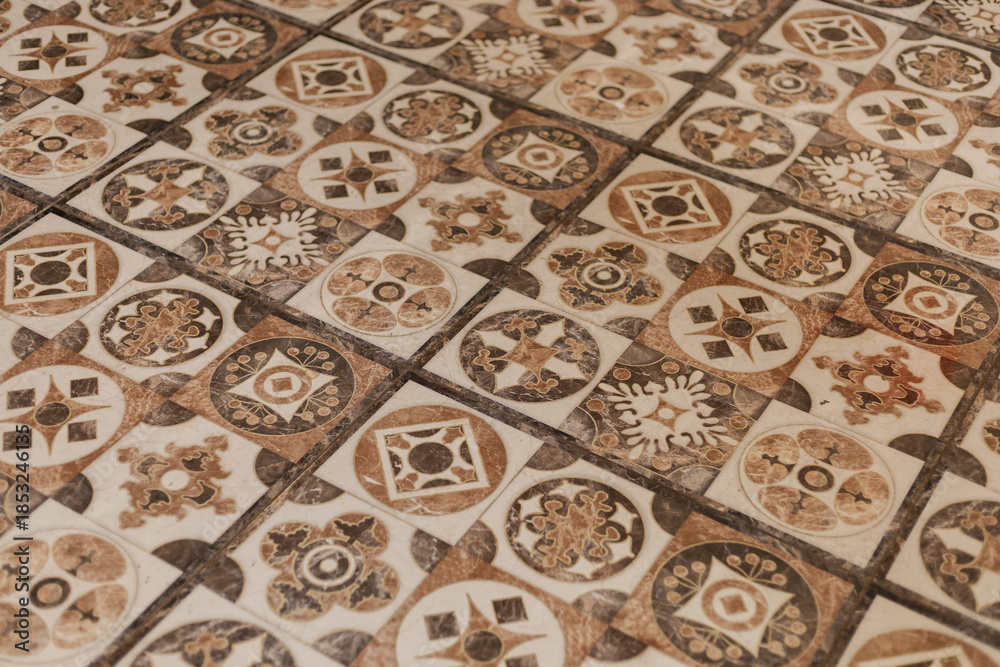 Obraz premium Ceramic tiles with colorful patterns fill the floor of a building. Each tile shows different designs that create a unique visual effect in the space