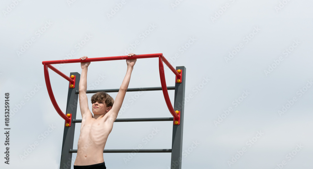 Naklejka premium A little boy is engaged in gymnastics equipment