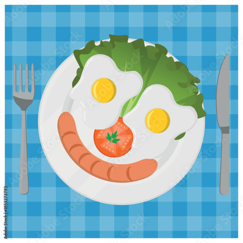 Smiley Face Breakfast made with Fried Egg Eyes, Sausage Mouth, and Vegetable Decorations on a Blue Checkered Tablecloth. Top View of A Delicious Breakfast Meal.