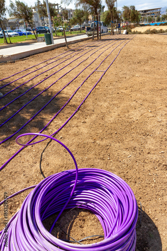 Installing automated watering system in garden field.