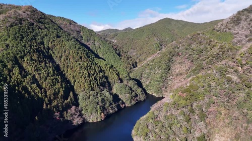 日本のドローン映像　冬の晴れた日に山と湖を前進しながら空撮
