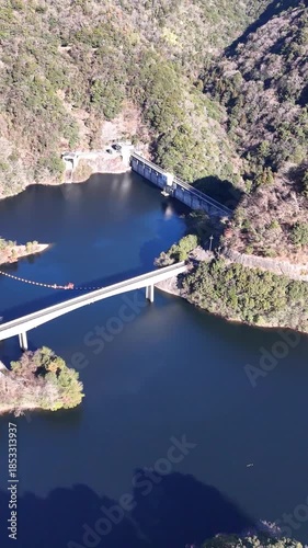 日本のドローン映像　冬の晴れた日にダム湖と橋を横移動しながら空撮