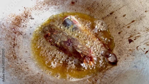 Deep Frying Fish Head in Traditional Kitchen Metal Pan