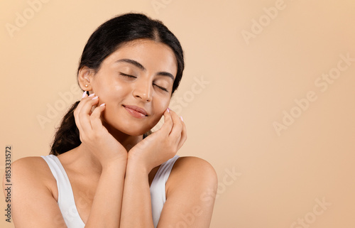 Φωτογραφία Sensual young indian woman with beautiful glowing skin posing against beige stud