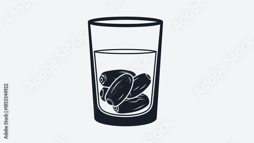 A glass of water with dates soaking inside, representing a healthy drink and Ramadan tradition.