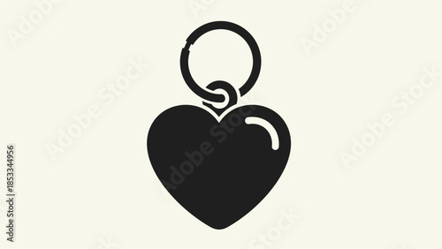 A simple black heart-shaped charm attached to a keyring, isolated on a light beige background.