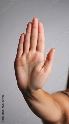 Female hand showing a stop gesture with an open palm and straight fingers
