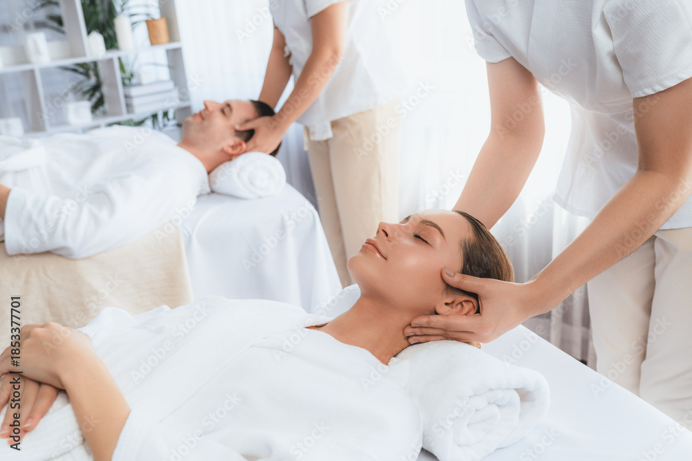 Obraz premium Caucasian couple enjoying relaxing anti-stress head massage and pampering facial beauty skin recreation leisure in dayspa modern light ambient at luxury resort or hotel spa salon. Quiescent