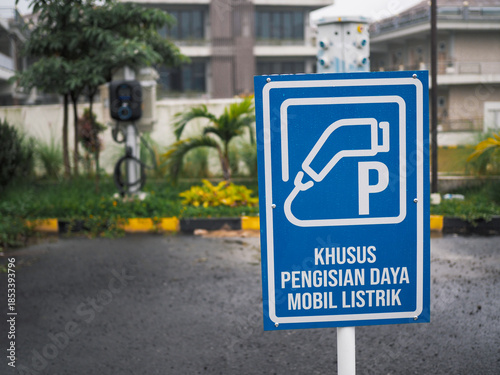Electric vehicle charging station signs stand in dedicated electric car parks.