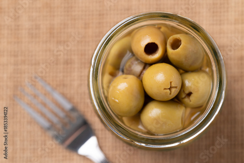 Foto Pickled olives, Pitted green olives in glass jar, Top view