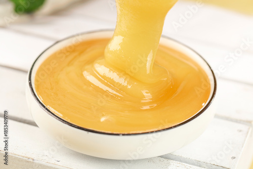 Photos Raw Honey Dripping into Bowl with Crystallized Texture